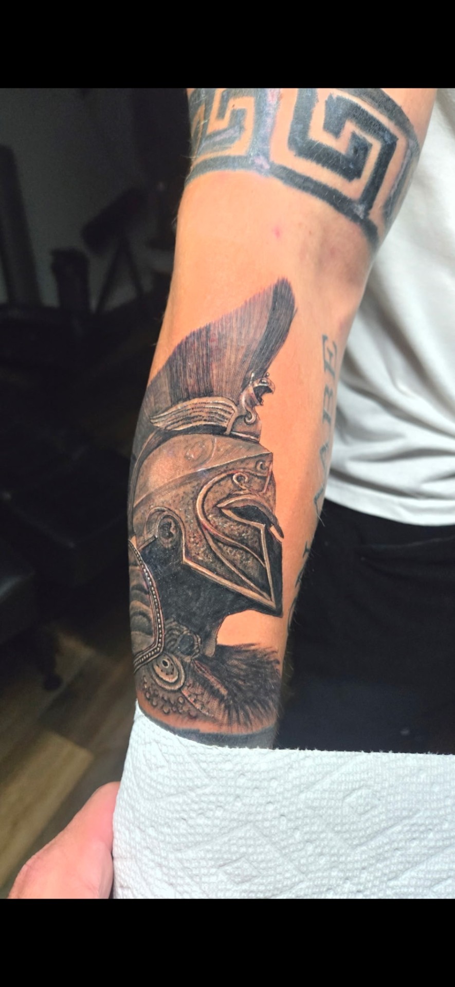 Black and grey realism Spartan helmet forearm tattoo by Kent Harrison