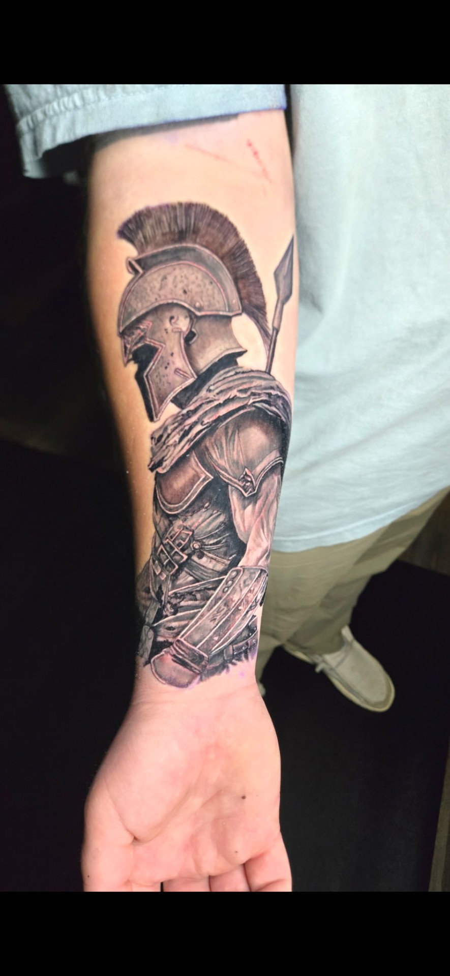 Black and grey realism Spartan warrior with helmet and spear forearm sleeve tattoo by Kent Harrison